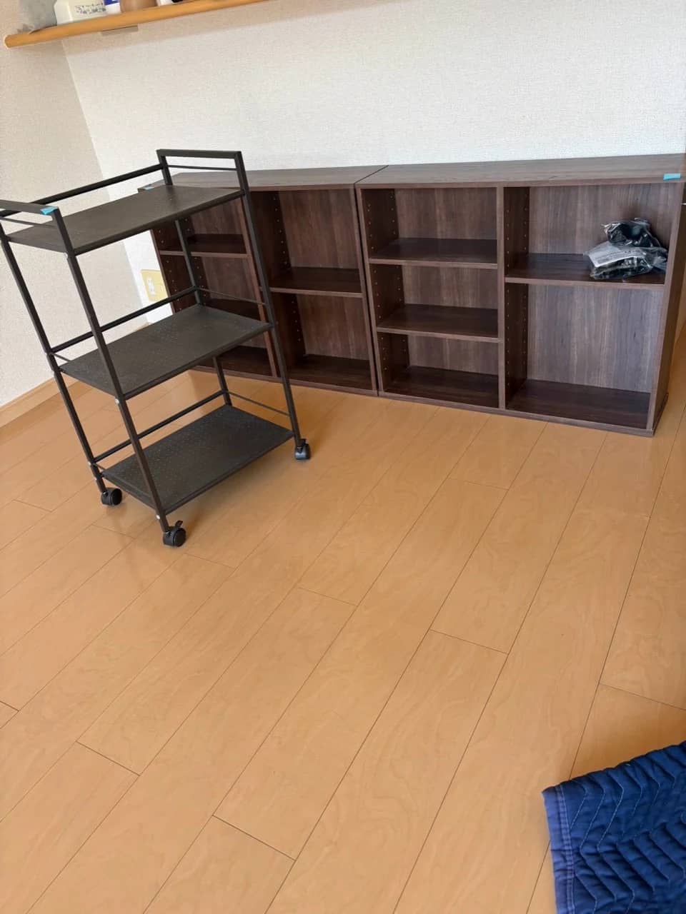 壁際に並べた棚とキャスター付きのワゴン