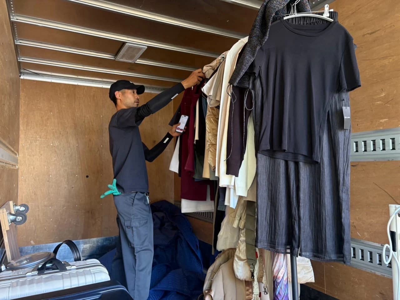 トラックの荷台でハンガーに掛けた洋服を扱うスタッフ