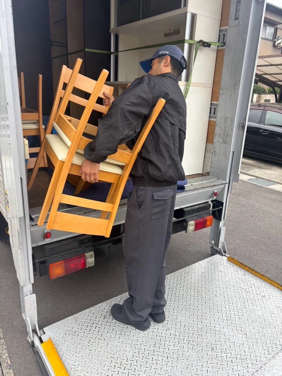 ダイニングチェアをトラックの荷台に積み込むスタッフ
