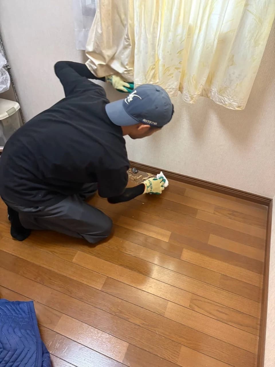 家具を搬出した場所の床を清掃するスタッフ