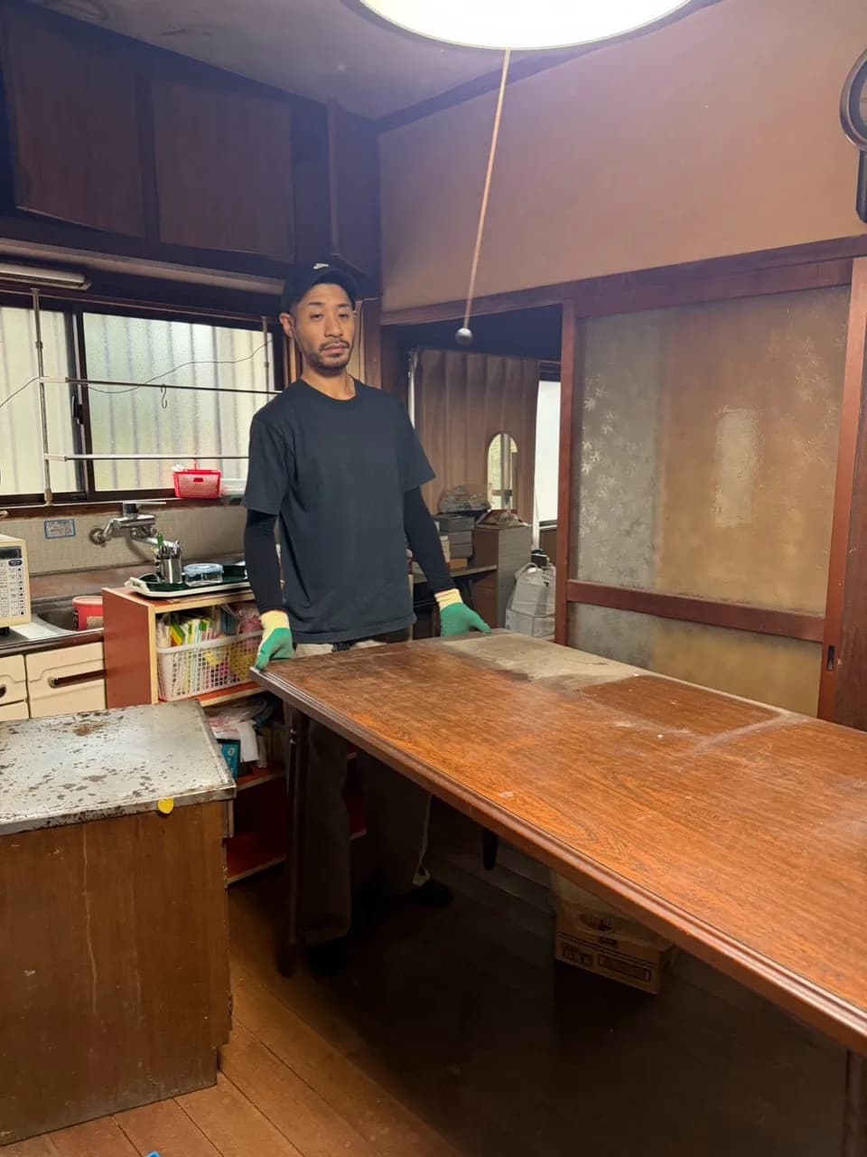 室内で大きな木製テーブルを支えるスタッフ