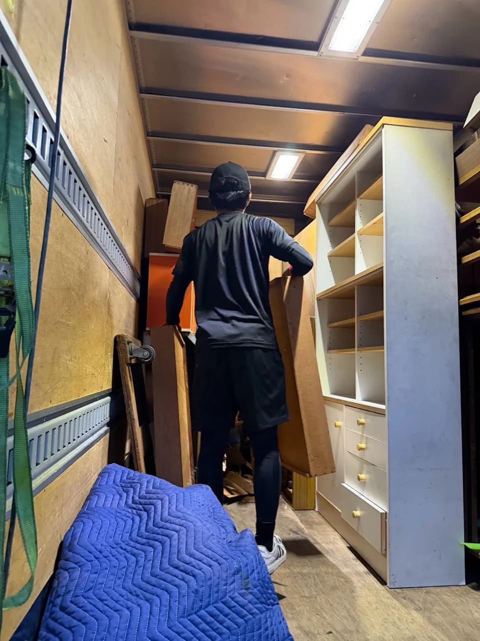 収納家具が並ぶトラックの荷台で木製の家具を積み込むスタッフ