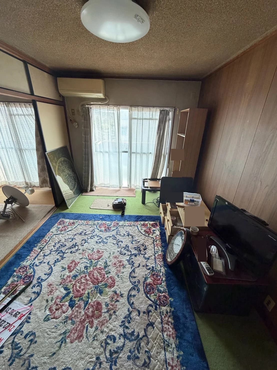 テレビや収納家具、敷物などが置かれた室内