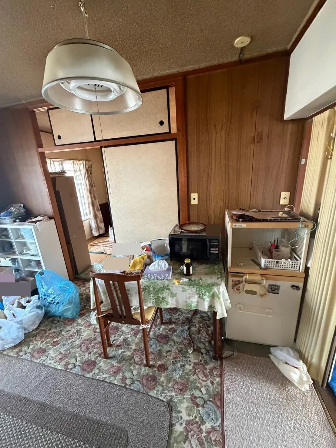 電子レンジを置いたテーブル、椅子、収納家具がある室内