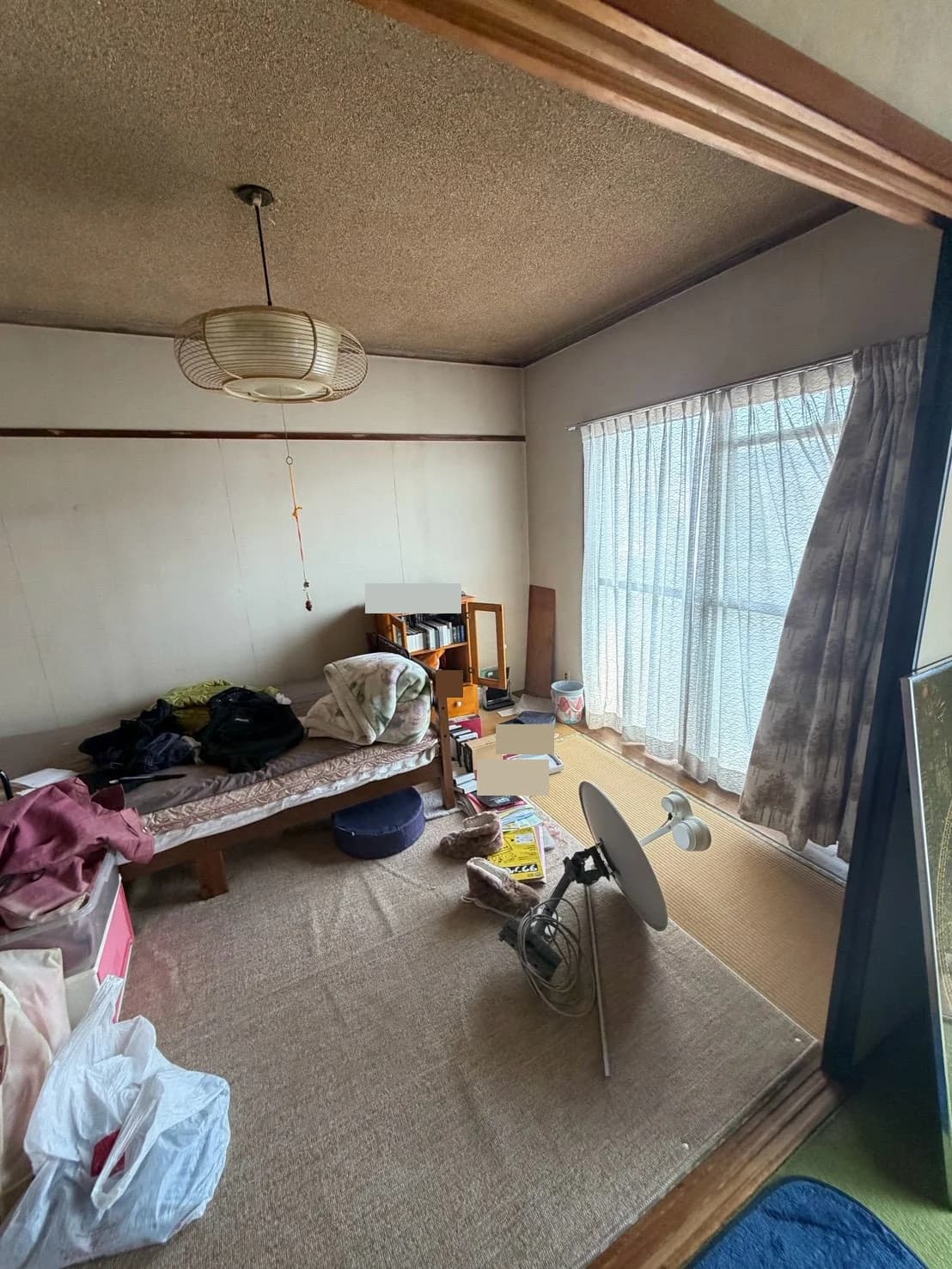 ベッドや棚、衣類、生活用品が置かれた室内