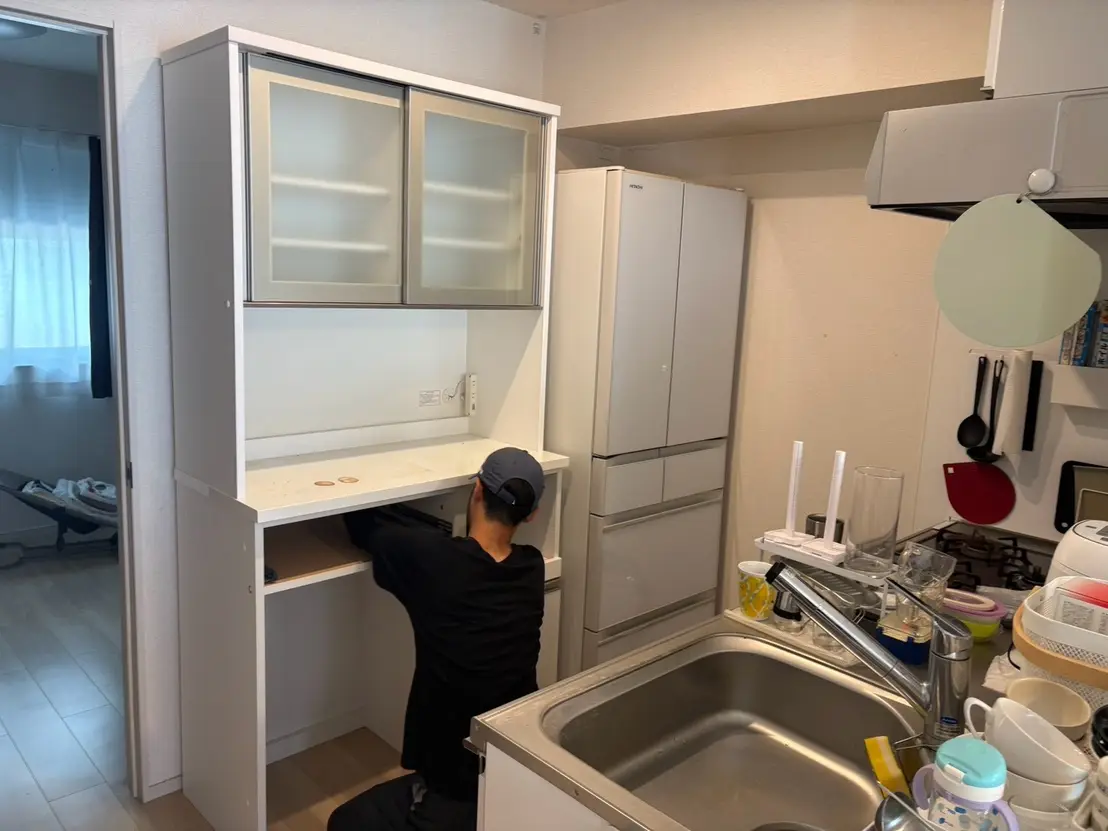 キッチンの食器棚と冷蔵庫を確認するスタッフ
