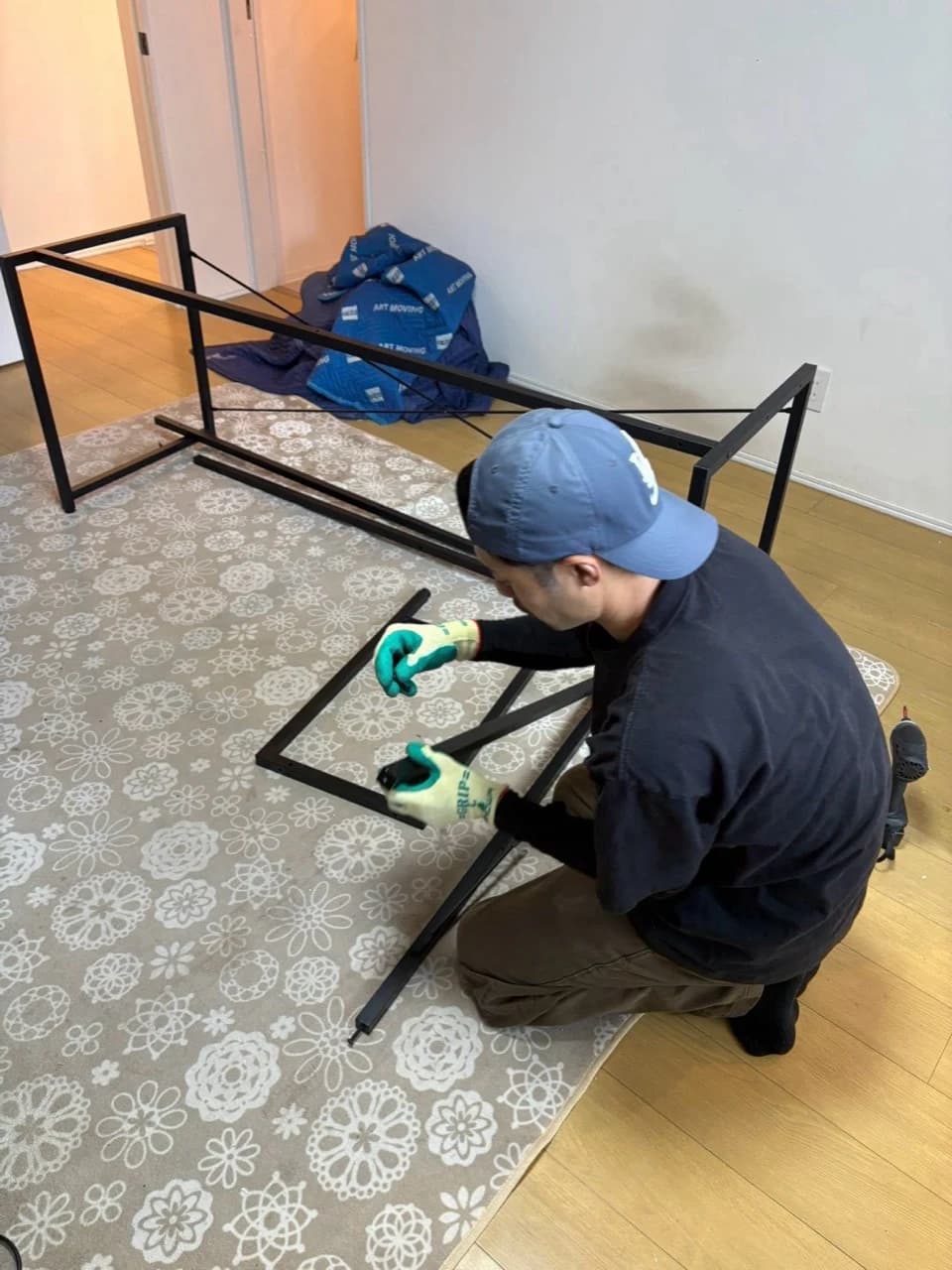 室内で家具のフレームを解体するスタッフ