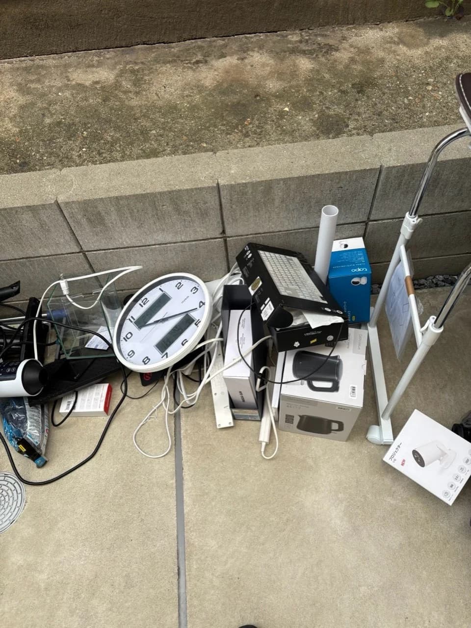 屋外に並べられた時計、家電、生活用品