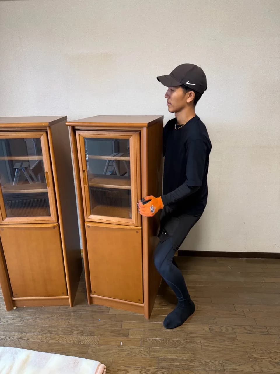 港区の3LDKマンションで木製の飾り棚を扱うスタッフ