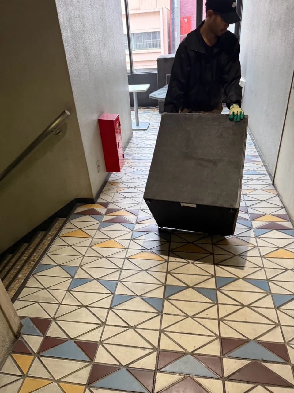 ソファを持って通路を進むスタッフ