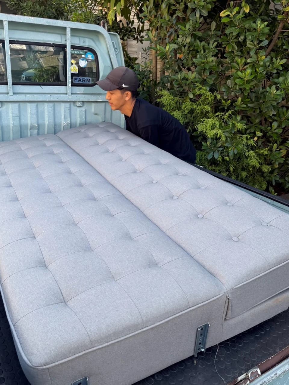 トラックの荷台にソファを載せるスタッフ