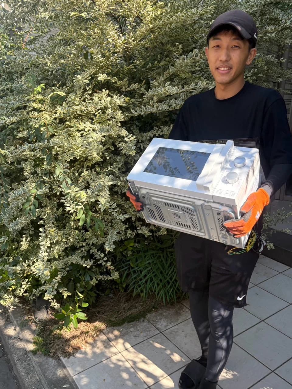電子レンジを運ぶスタッフ
