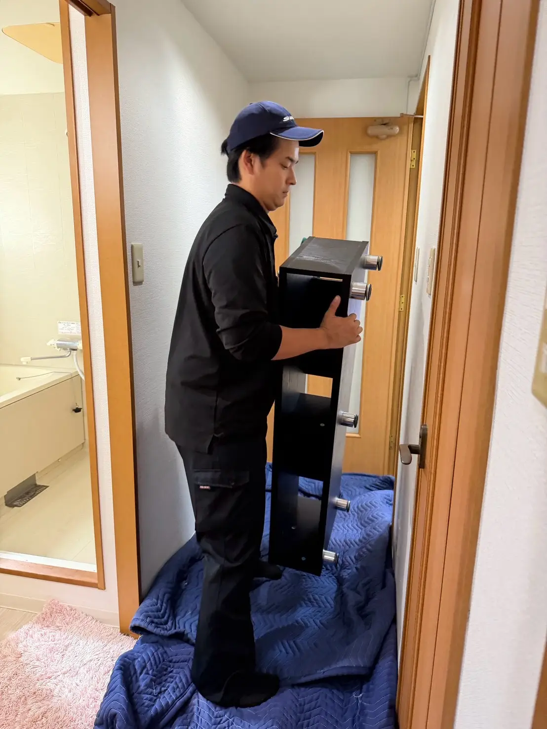 黒いラックを運び出すスタッフ
