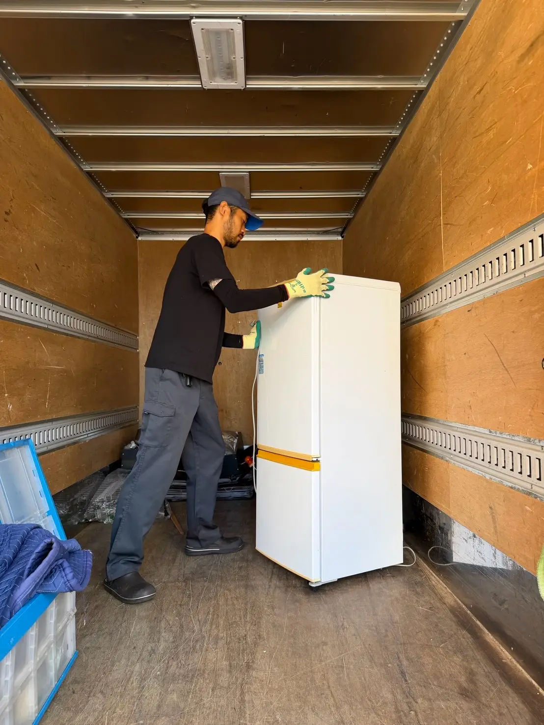 トラックの荷台に冷蔵庫を積み込む様子