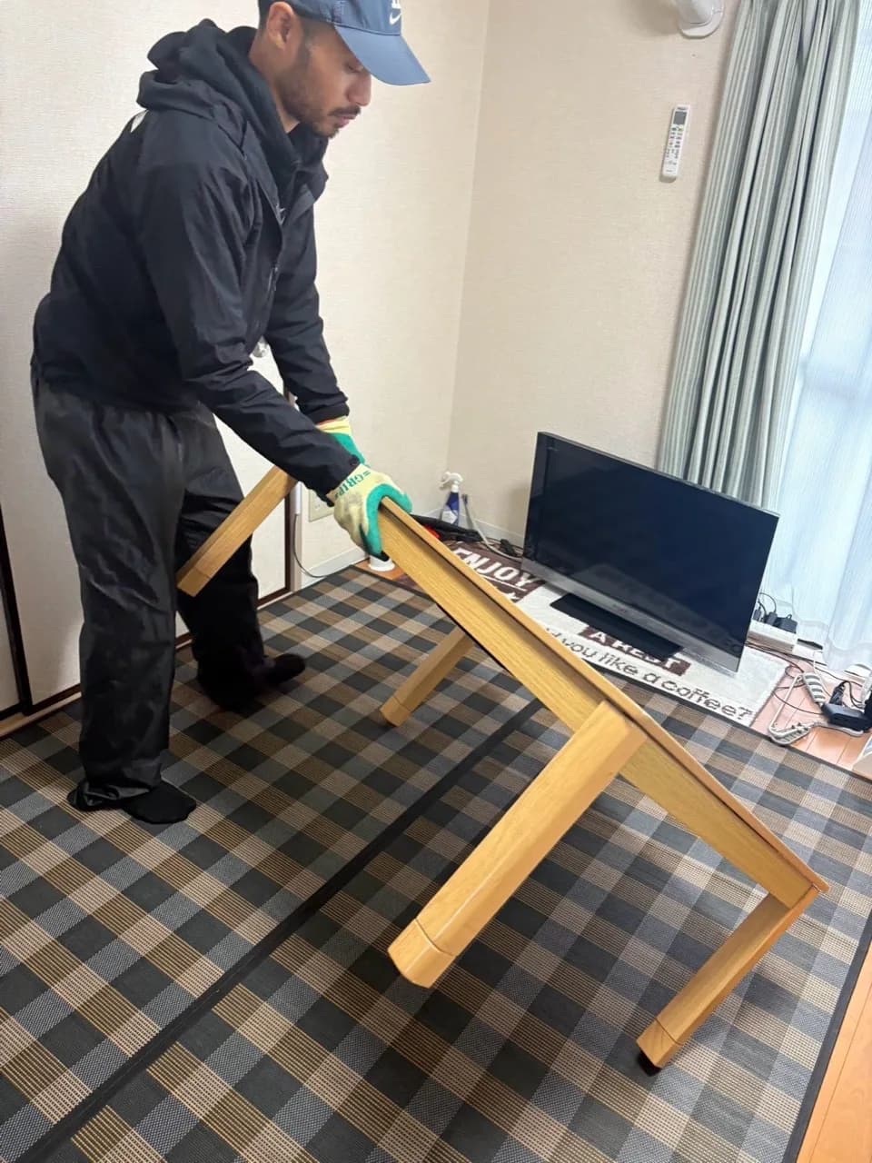 名古屋市天白区の室内で木製テーブルを扱うスタッフ