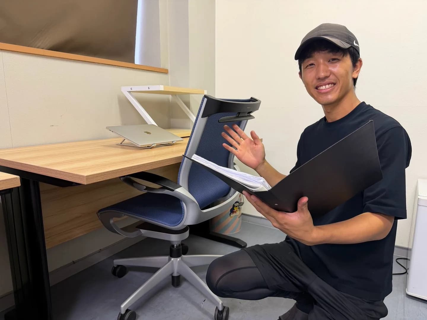 オフィスの家具のそばで書類を手にするスタッフ
